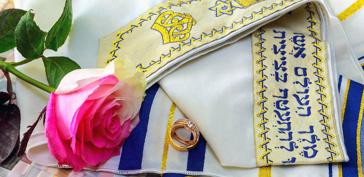 Wedding rings and roses on prayer shawl