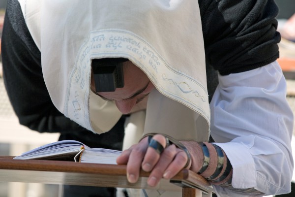 A Jewish man with a tallit (prayer shawl) over his head recites morning prayer Jerusalem-Kotel-morning prayer