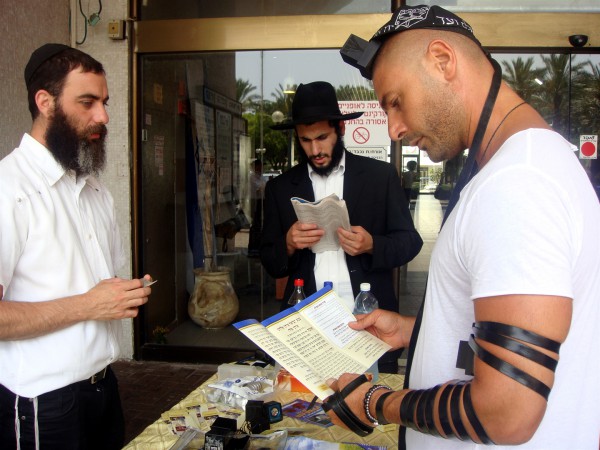 Chabad-Lubavitch Jewish men help a secular Jewish man put on tefillin Lubavitcher-Jews-Shabbat-Tefillin