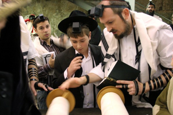Young man reciting prayers at the Western (Wailing) Wall reading-Torah-Bar Mitzvah-tefillin-phylacteries