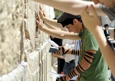 Young man reciting prayers at the Western (Wailing) Wall Praying-Western Wailing-Wall-Jerusalem-tefillin