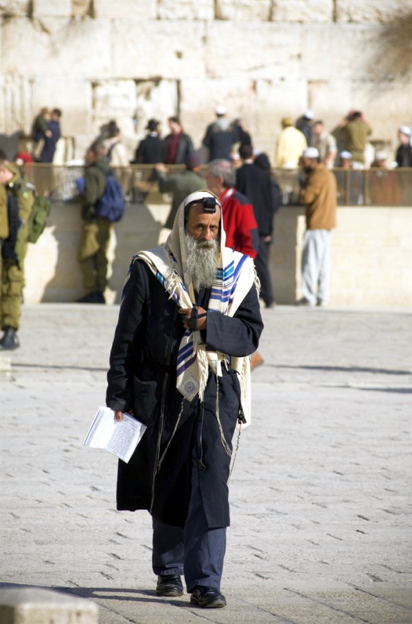 An Orthodox Jewish man wears a tallit (prayer shawl) and tefillin (phylacteries) for morning prayer Jewish man-tallit-shawl-tefillin-morning prayer