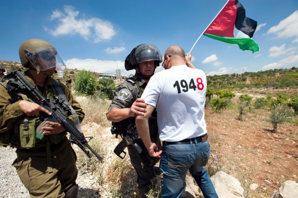 A Palestinian activist blocks an Israeli soldier on Nakba Day Nakba Day