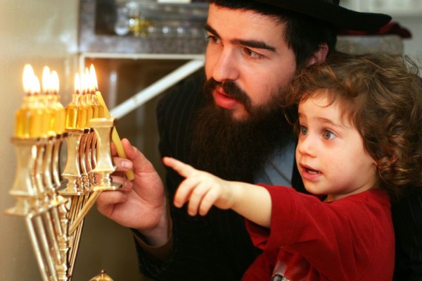 A Jewish child watches as his father kindles the eight lights on the Chanukah menorah, also called the Chanukiah. Menorah, Chanuakah, Chanukiah, lighting