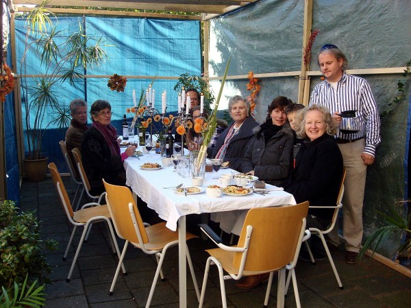 Dutch Jews enjoy a meal in the sukkah built by the Beth Shoshanna Congregation at the Great Synagogue of Deventer. Loofhut_van_Beth_Shoshanna_2-by-Tfursten-Great-Synagogue-of-Deventer
