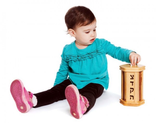 Toddler puts charity in the tzedakah (pushke) box Toddler puts charity in the tzedakah (pushke) box