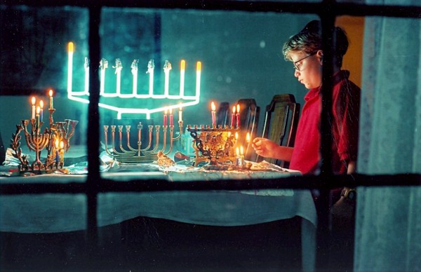 A Jewish boy lights multiple Hanukkah menorahs on the second night ofHanukkah Chanukkah-Hanukkah-menorah-hanukkiah