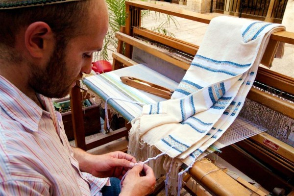 A Jewish artisan who weaves tallitot ties the tzitzit to the four corners of the garment. (Israel photo gallery by Noam Chen) A Jewish artisan who weaves tallitot ties the tzitzit to the four corners of the garment. (Israel photo gallery by Noam Chen)