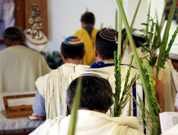 Jewish men pray in a synagogue on Sukkot. They are holding Sukkot's Arba'ah Minim (Four Kinds of plant), which are mentioned in Leviticus 23:40. Jewish men pray in a synagogue on Sukkot. They are holding Sukkot's Arba'ah Minim (Four Kinds of plant), which are mentioned in Leviticus 23:40.