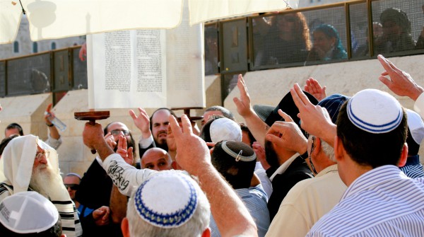 Men reach out to pay respect to the Torah as it is raised at the Western (Wailing) Wall in Jerusalem. (Photo by opalpeterliu) Men reach out to pay respect to the Torah as it is raised at the Western (Wailing) Wall in Jerusalem. (Photo by opalpeterliu)
