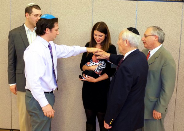 A newborn's great-grandfather, grandfather, and uncle recite the priestly blessing over her. (Photo by Avi and Elina Flax) A newborn's great-grandfather, grandfather, and uncle recite the priestly blessing over her. (Photo by Avi and Elina Flax)