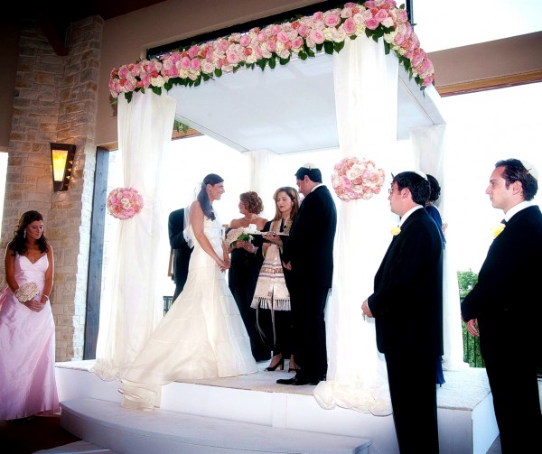 A Jewish wedding is conducted under the chuppah, which symbolizes the home the couple will build together. A Jewish wedding is conducted under the chuppah, which symbolizes the home the couple will build together.