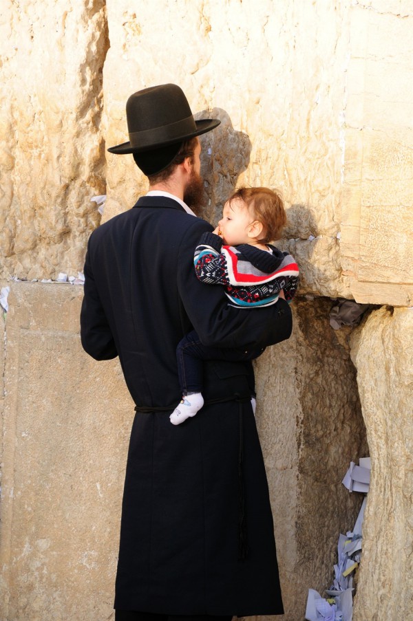 A Jewish father holds his child close as he prays at the Western (Wailing) Wall in the Old City of Jerusalem. A Jewish father holds his child close as he prays at the Western (Wailing) Wall in the Old City of Jerusalem.