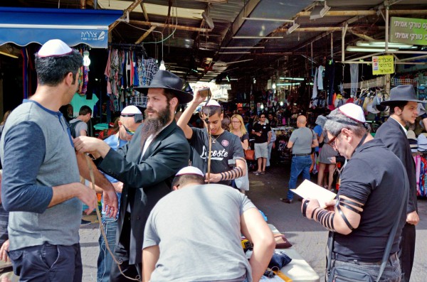 Ultra-Orthodox Jewish men in Tel Aviv show a passersby how to put on tefillin (phylacteries) and pray. Ultra-Orthodox Jewish men in Tel Aviv show a passersby how to put on tefillin (phylacteries) and pray.