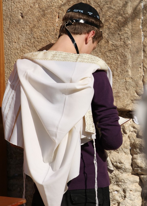 A Jewish teen wearing a tallit (prayer shawl), tefillin (phylacteries), and a kippah (head covering) prays at the Western (Wailing) Wall in Jerusalem. (Photo by the State of Israel) A Jewish teen wearing a tallit (prayer shawl), tefillin (phylacteries), and a kippah (head covering) prays at the Western (Wailing) Wall in Jerusalem. (Photo by the State of Israel)