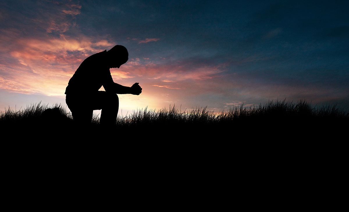 Man praying, kneeling